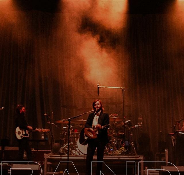 Banda tocando ao vivo no palco com luz quente